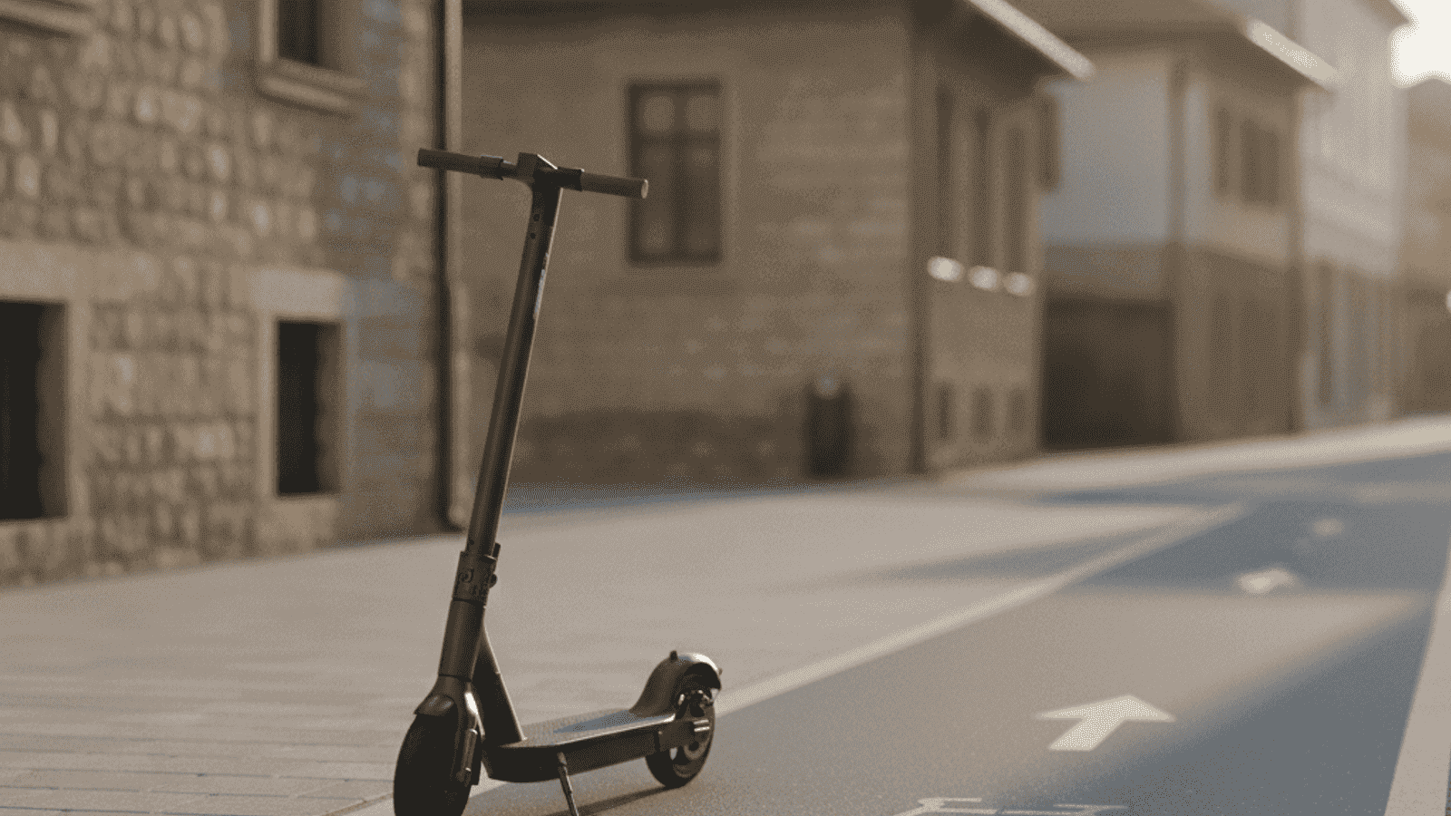 Električni romobil parkiran na gradskom trotoaru pored biciklističke staze u urbanom okruženju s kamenim zgradama u pozadini